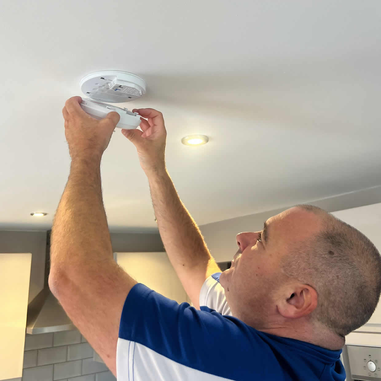 Smoke alarm being installed on a ceiling in King's Lynn